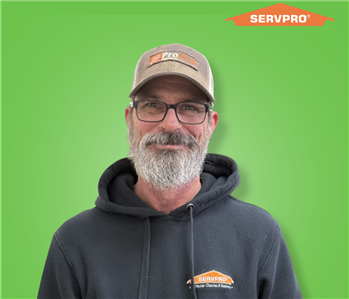 male employee wearing a black SERVPRO hoodie and a hat