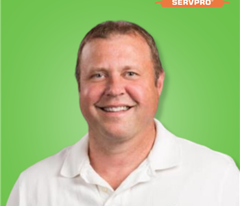 male employee smiling in a white polo
