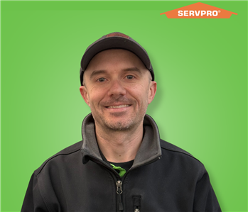 male employee wearing a black SERVPRO jacket and hat