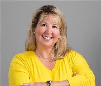 Blonde woman smiling in front of white background 