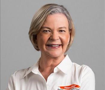 Blonde woman smiling in front of white background 