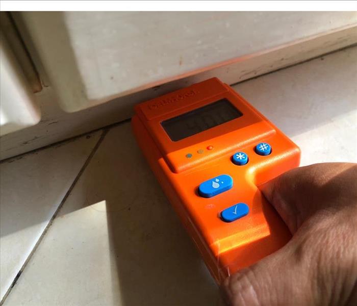 orange moisture meter in wall